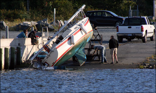 Assessing a sailboat mishap Monday evening at the boat slip next to the south jetty on the Bedford Waterfront.