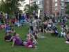 Folks sit on the grass to take in the evening's entertainment.