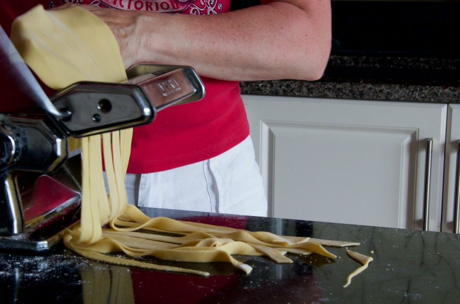 pasta sheet being cut into noodles
