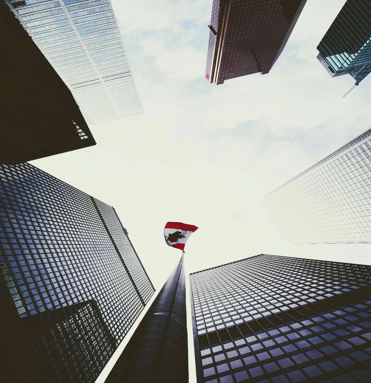 Free Dramatic low angle view of skyscrapers surrounding a Canadian flag in downtown Toronto. Stock Photo